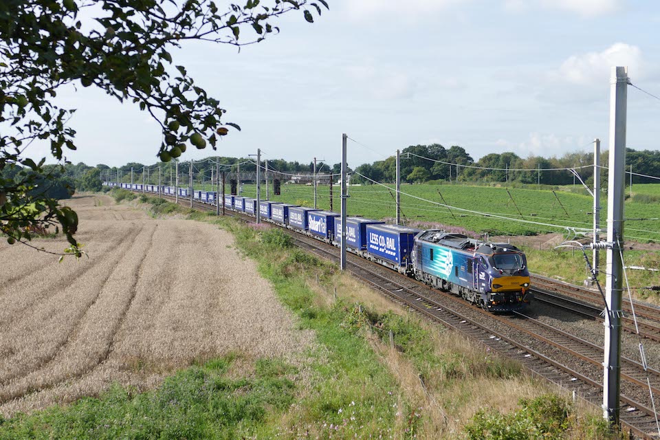 Tesco train being headed by a DRS class 88 bi-mode locomotive under the wires in the countryside at Golborne in Lancashire