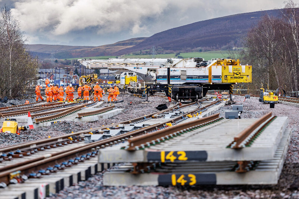 Engineers busy over track layout in a rural setting with the Pennines in the background